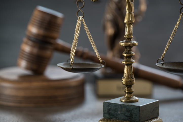 The scales of justice in front of a gavel. 