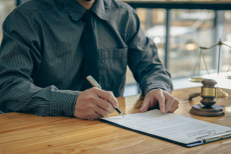 A worker's compensation lawyer working on paperwork at his desk.