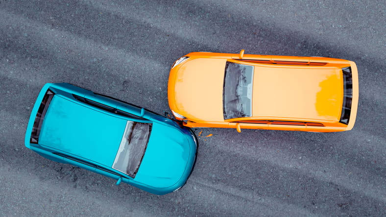 An aerial view of a minor car accident between a blue and orange car.