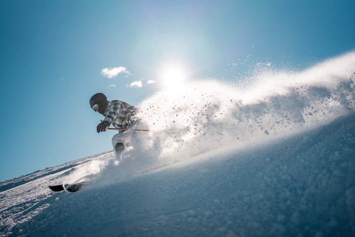 A person skiing down a slope at high speeds.